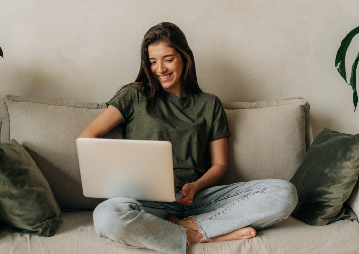 A woman writing a review on her laptop for online medical certificate service.