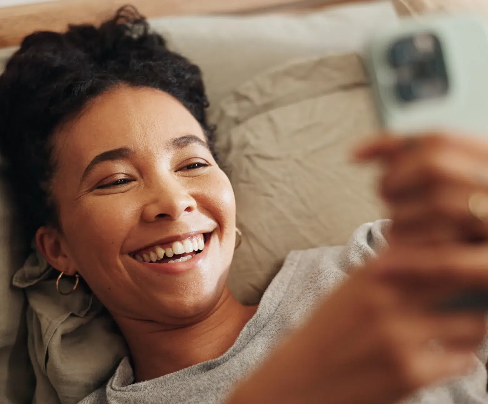 woman-telehealth-via-phone-from-bed-hola-health-gp