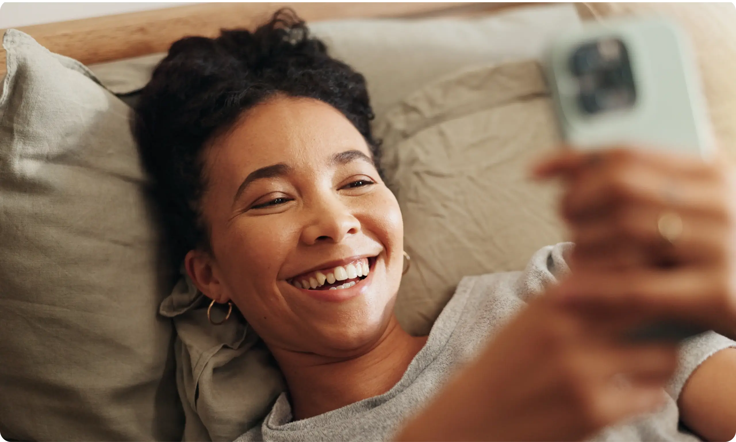 woman-telehealth-via-phone-from-bed-hola-health-gp