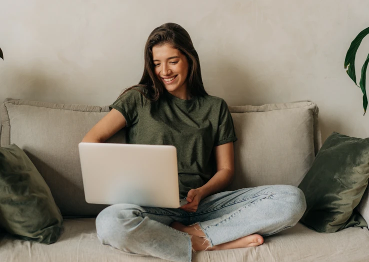 A woman writing a review on her laptop for online medical certificate service.